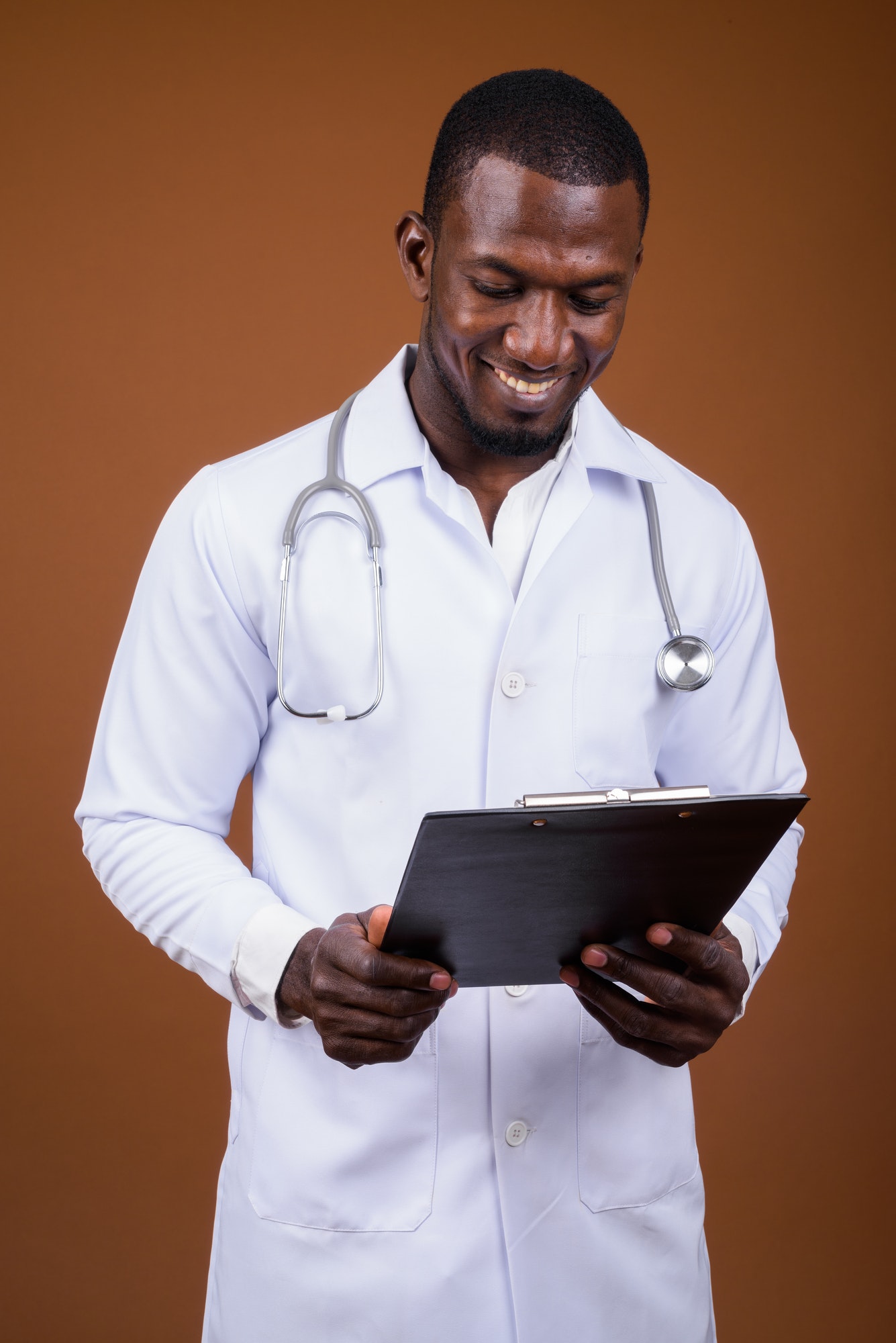 Handsome African man doctor against brown background